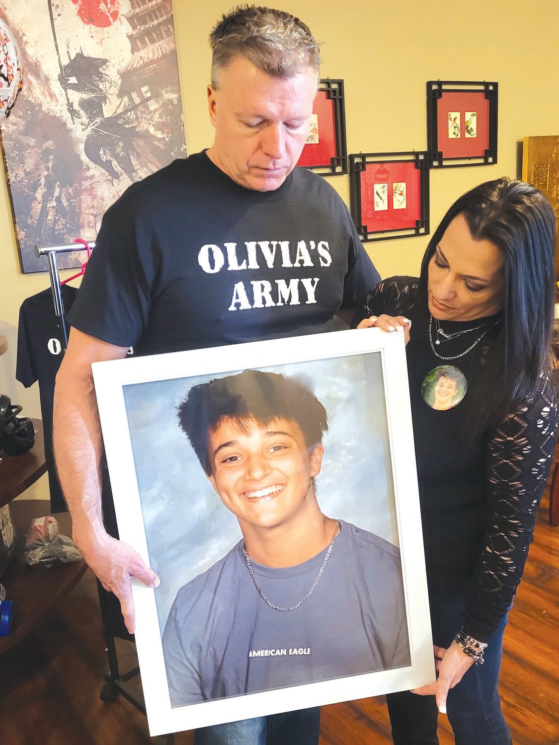 JUSTICE FOR OLIVIA: Dennis Molloy and Janine Passaretti-Molloy hold a portrait of their daughter, Olivia, who was killed in a crash on New Year’s Eve. (Warwick Beacon photos by Rory Schuler) OLIVIA 2 shirts RS